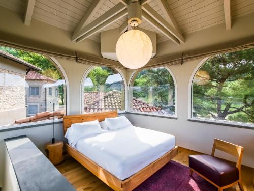 ein Schlafzimmer mit einem Bett und zwei Fenstern in der Unterkunft Hemanaire in Cremolino