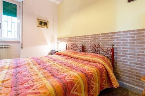 Un dormitorio con una cama con una pared de ladrillos. en Villino Carolina 30 mt mare, en Porto Cesareo