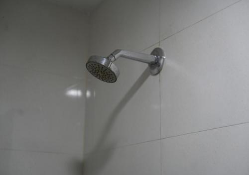a shower with a shower head in a bathroom at Hotel Laasya Grand in Vijayawāda