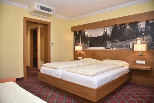 a hotel room with two beds and a painting on the wall at Hotel Gasthof Kamml in Wals