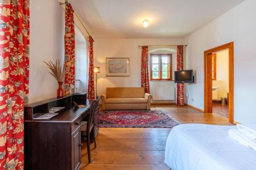a bedroom with a bed and a desk in a room at Schlosshotel Mailberg in Mailberg