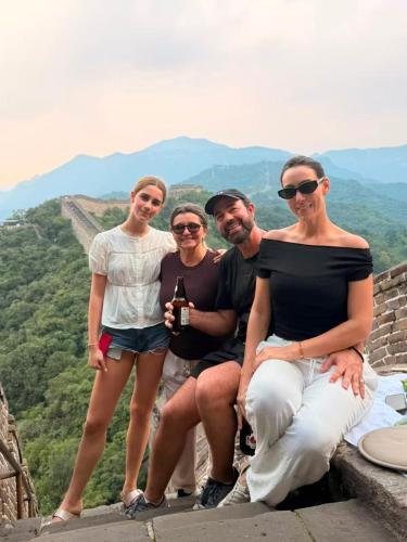 a group of people posing for a picture on the great wall at BeiJing Mutianyu Hills Pool Wall Resort view at the foot of Mutianyu Great Wall, infinity pool, one-way PEK airport pick-up, free laundry and coffee in Huairou
