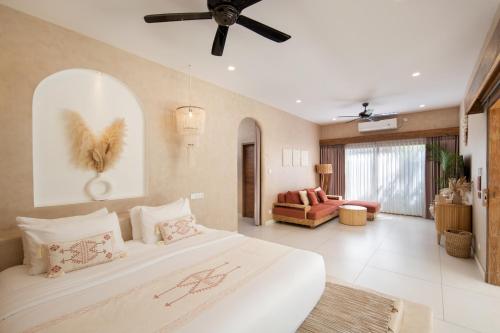 a bedroom with a large bed and a living room at Gili Boho Villas - Aesthetic Private Pool Villas in Gili Trawangan
