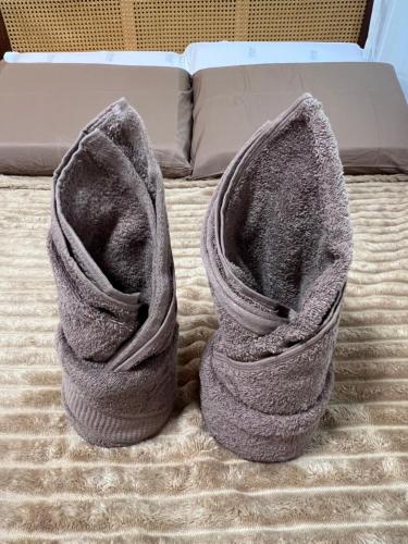 a pair of gray shoes sitting on a bed at The LineUp Surf House Pacifico in San Isidro