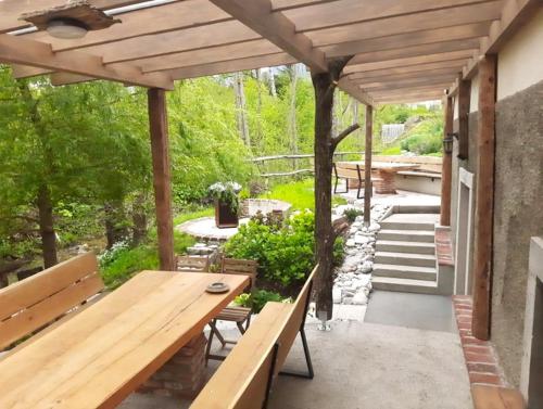 a patio with a wooden table and benches at Apartment House Belca in Preddvor