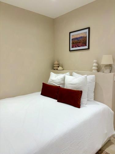 a white bed with white pillows in a bedroom at Le Cocon Provençal in Monteux
