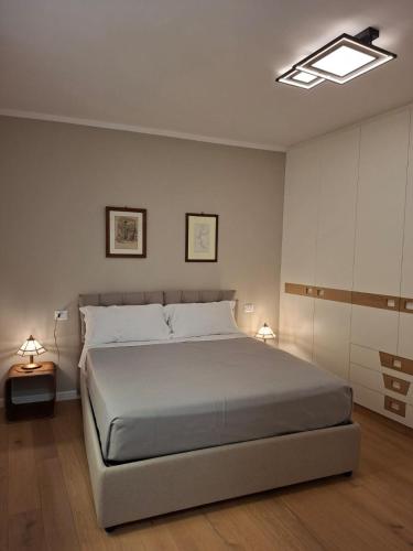a bedroom with a large bed and two lamps at The Secret Lakeside in Gravedona