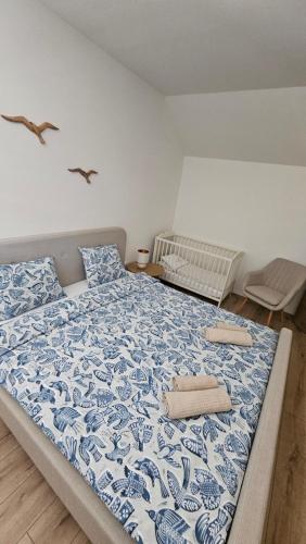 a bedroom with a blue and white bed with two towels on it at Vila Castrum in Nové Zámky