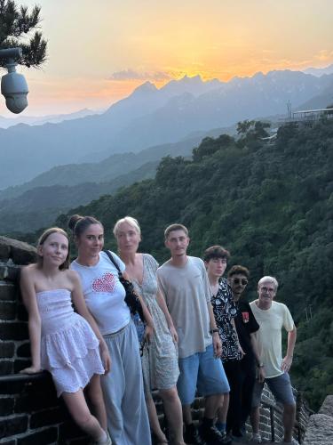 a group of people standing on top of a mountain at BeiJing Mutianyu Hills Pool Wall Resort view at the foot of Mutianyu Great Wall, infinity pool, one-way PEK airport pick-up, free laundry and coffee in Huairou