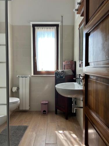 a bathroom with a sink and a toilet and a window at Villa Nina in Caporciano