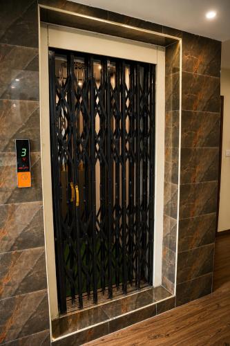 a black iron gate on a stone wall at Hotel Savithas Grand in Vijayawāda
