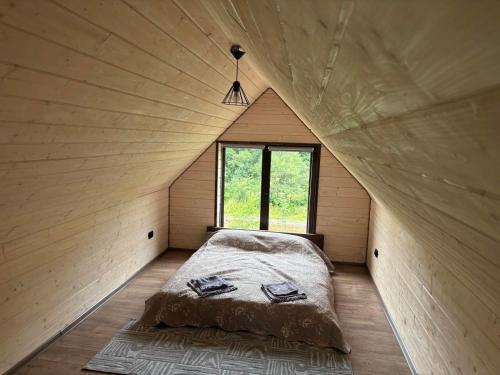 a bed in a small room with a window at Тиша біля річки in Izki
