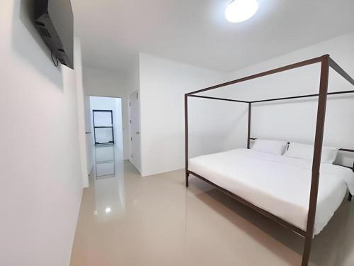 a bedroom with a canopy bed and a mirror at WICKET WHITE VILLA in Ban Bang Lao (3)
