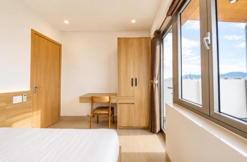a bedroom with a desk and a bed and a window at Minh Khang Apartment in Danang