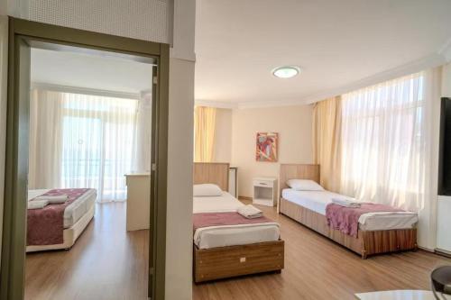 a hotel room with two beds and a mirror at Nagidos Hotel in Bozyazı