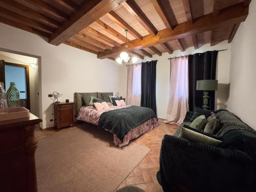 a bedroom with a bed and a couch at Villa Anastasia in Carpi