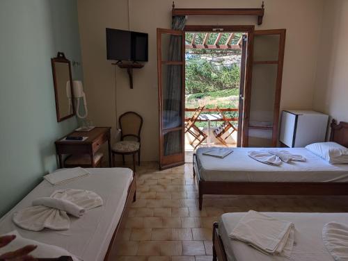 a room with two beds and a television and a window at Maistrali in Galissas