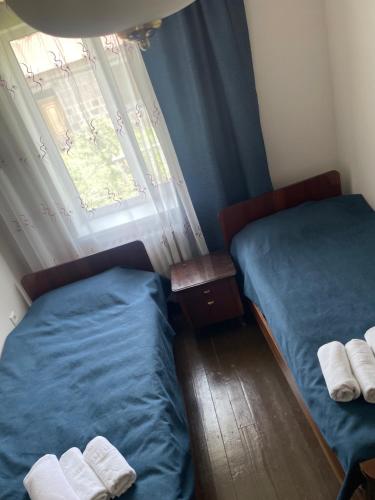 two twin beds in a room with a window at Sis Guest House in Tsʼoghamarg