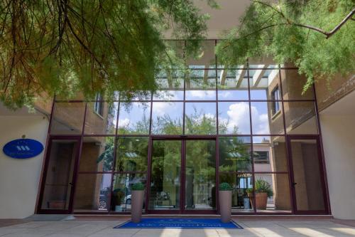 an office building with glass doors and potted plants at Hotel Centro Congressi Polo Nautico in Salerno