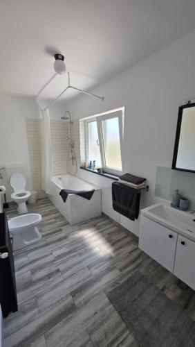 a bathroom with two sinks a toilet and a tub at Casa Magurele 5 in Măgurele