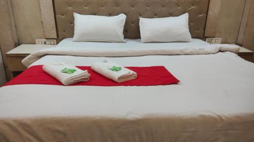 two towels are sitting on top of a bed at Triveni Inn in Jahāngīrābād