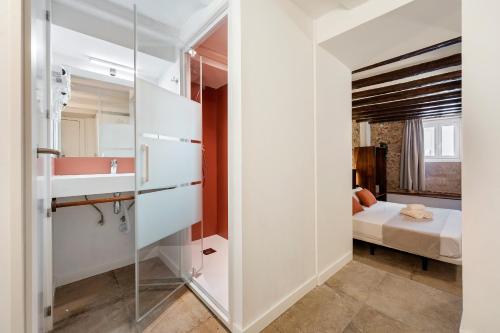 a bathroom with a glass door leading to a bedroom at Port Apartsuite in Tarragona