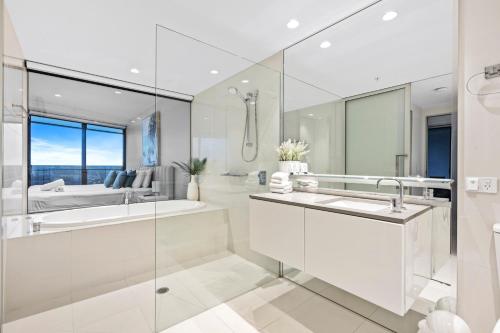 a white bathroom with a tub and a sink at Circle on Cavill Apartments - Hosted by WowStay in Gold Coast