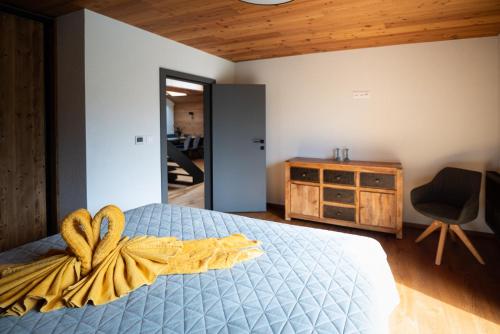 a bedroom with a bed with a yellow blanket and a dresser at Great Lake in Nová Baňa