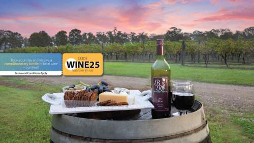 a bottle of wine and a plate of cheese and bread at The Glass Ceiling 360 degree Mount View Hideaway in Mount View