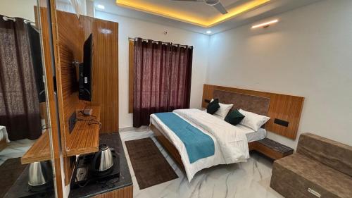 a bedroom with a bed and a television in it at Hotel The SunGod in Uttarkāshi