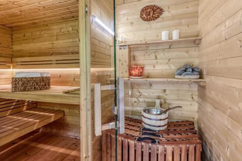 a sauna in a wooden cabin with a bucket at Roubenka Kailas in Červená Voda