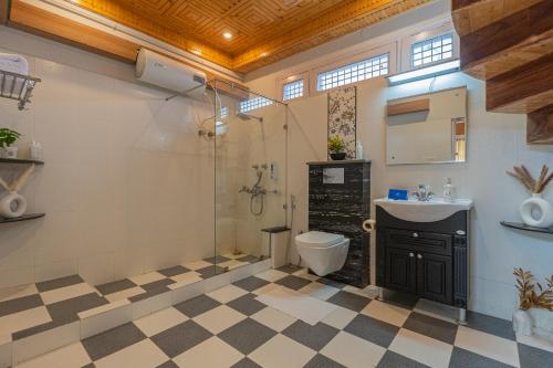a bathroom with a shower and a toilet and a sink at SaffronStays StoneVilla in Shimla