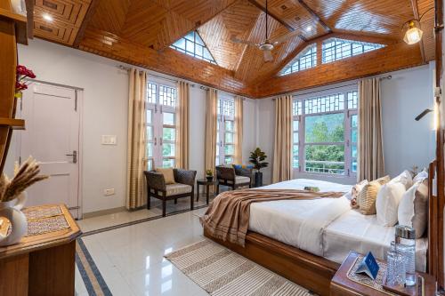 a bedroom with a large bed with a wooden ceiling at SaffronStays StoneVilla in Shimla