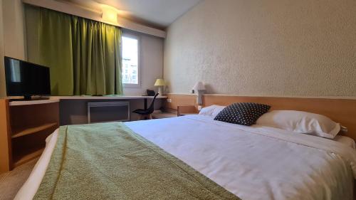 a bedroom with a large bed and a television at Sweet Home in Belley