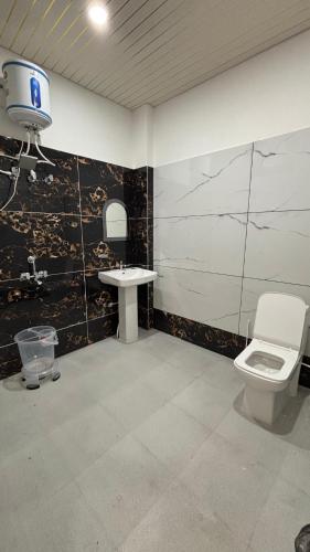 a bathroom with a toilet and a sink at Hotel The SunGod in Uttarkāshi