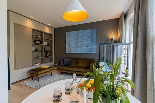 a living room with a table and a couch at OHotellMe City Apartments Rotterdam in Rotterdam