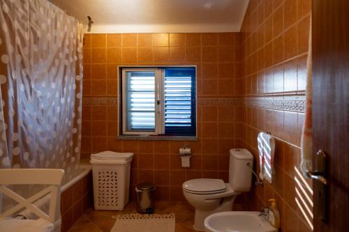 a bathroom with a toilet and a window at Casa de Sume in Monte da Pedra