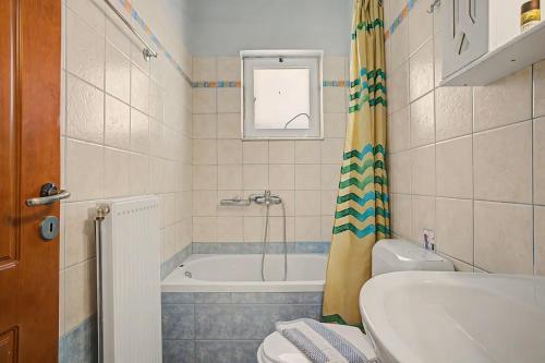 a bathroom with a tub and a toilet and a sink at Dimitra Apartments Zakros Village in Kato Zakros