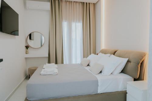 a bedroom with a bed with white pillows and a mirror at Chez Jean in Argos