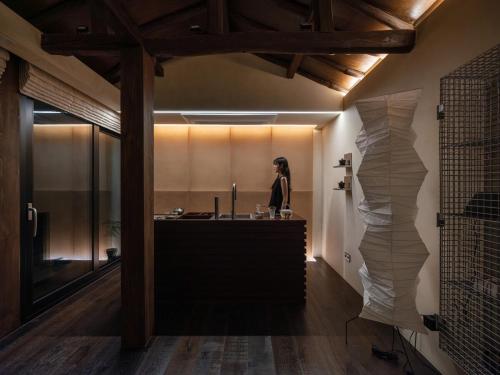 a woman is standing in a kitchen with a counter at 한옥스테이 서유재 in Ch'unch'ŏn-yŏk