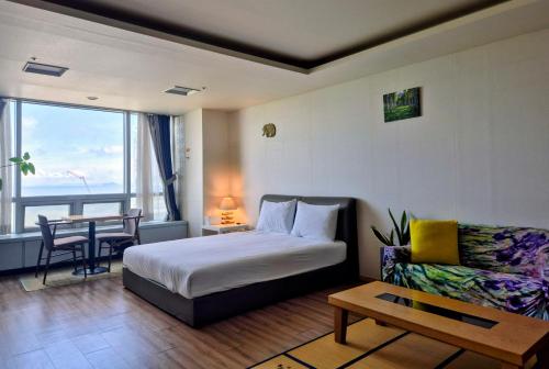 a bedroom with a bed and a table and a couch at Cozy - Bright Studio in Incheon