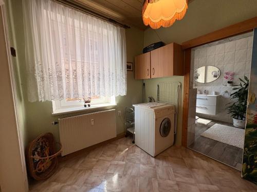 a laundry room with a washing machine and a window at Ferienwohnung Heidi in Annaberg-Buchholz