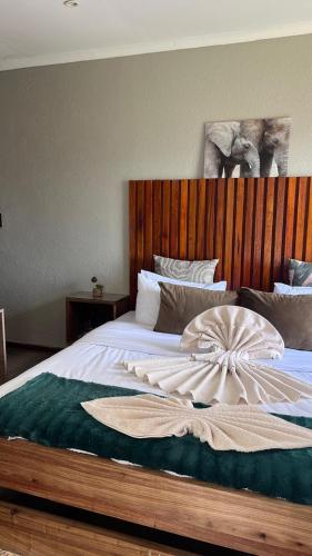 a bedroom with a large bed with a wooden headboard at Pine View Guesthouse Graskop in Graskop