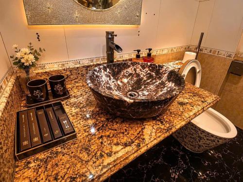 a bathroom with a granite sink and a toilet at Việt Anh Hotel in Sapa
