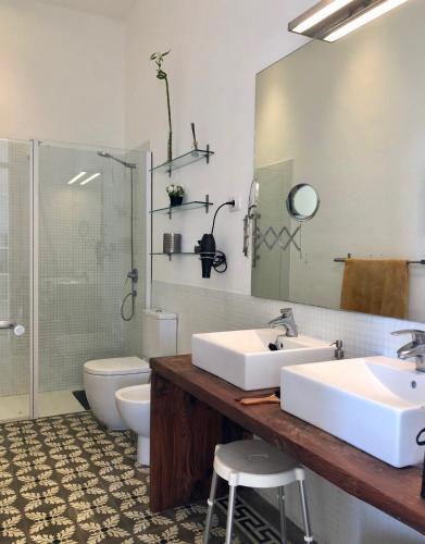 a bathroom with two sinks and a toilet and a shower at Casa La Breña La Palma in Breña Baja