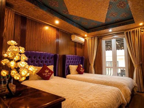 a bedroom with two beds and a table with flowers at Việt Anh Hotel in Sapa