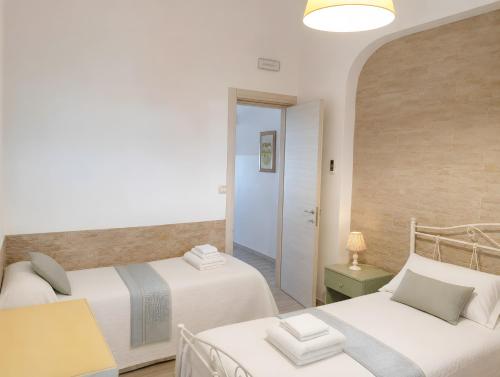 a bedroom with two beds and a hallway at Marea Blanca in Porto Cesareo
