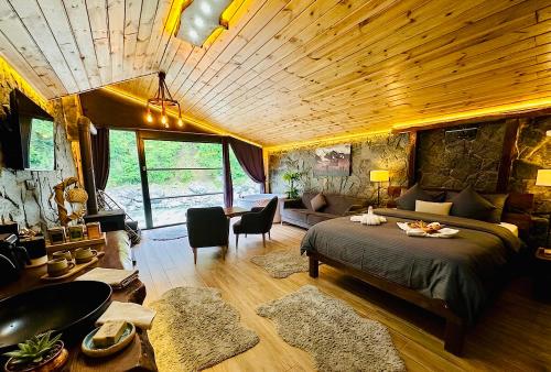 a bedroom with a large bed and a living room at Ayder Royal River Resorts - Bungalows & Hotels in Çamlıhemşin