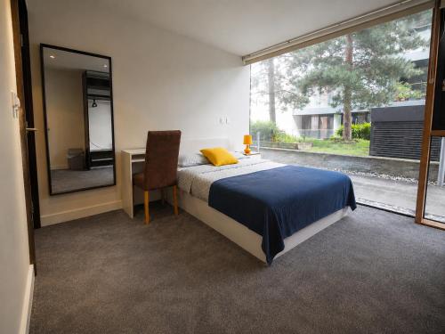 a bedroom with a bed and a desk and a mirror at Beacon Guest Rooms Sandyford in Sandyford