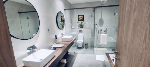 a bathroom with two sinks and a shower at Ira By Orchid Bhavnagar in Bhavnagar